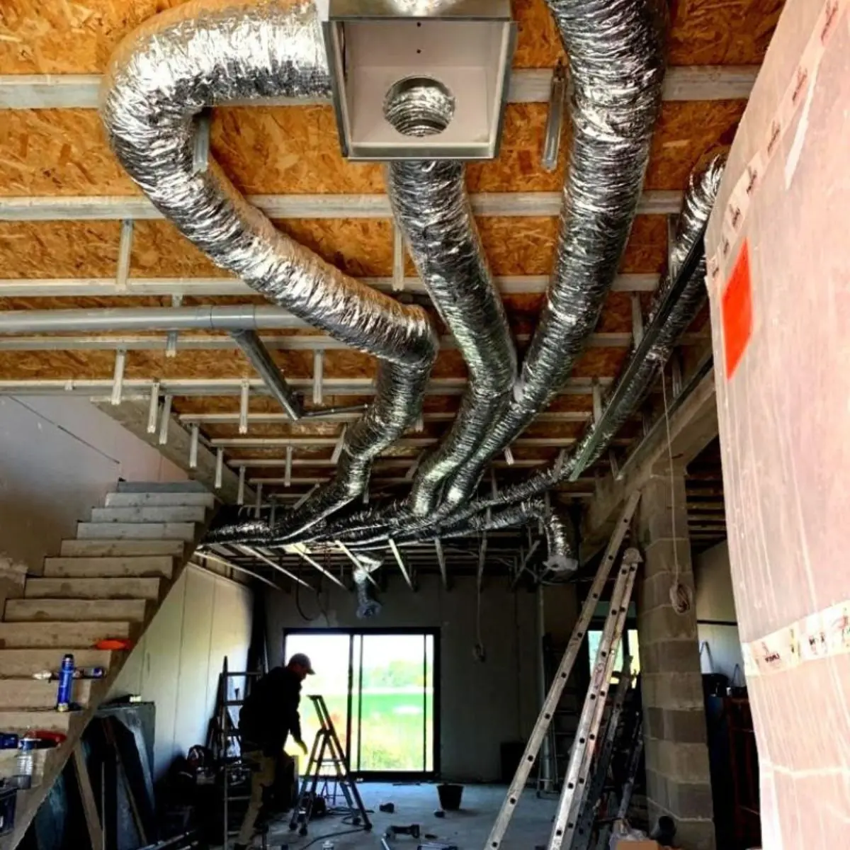 Technicien Proclim installant les gaines d'une climatisation gainable